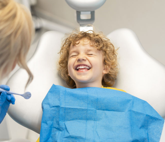 bambino che mostra un dente da latte al dentista